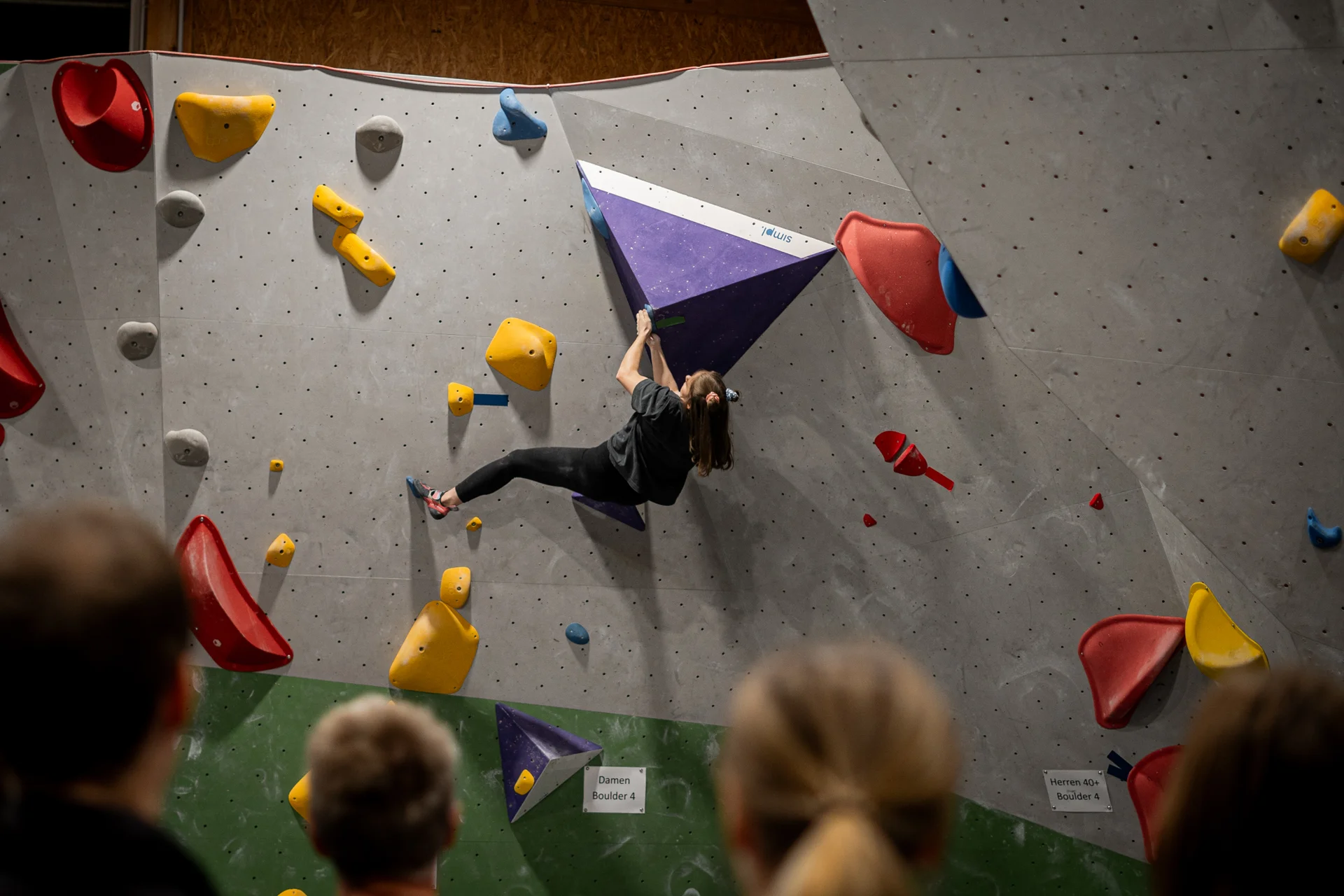 Frau beim Bouldern an der blauen Route | © diekletterarena Frau beim Bouldern an der blauen Route | © diekletterarena