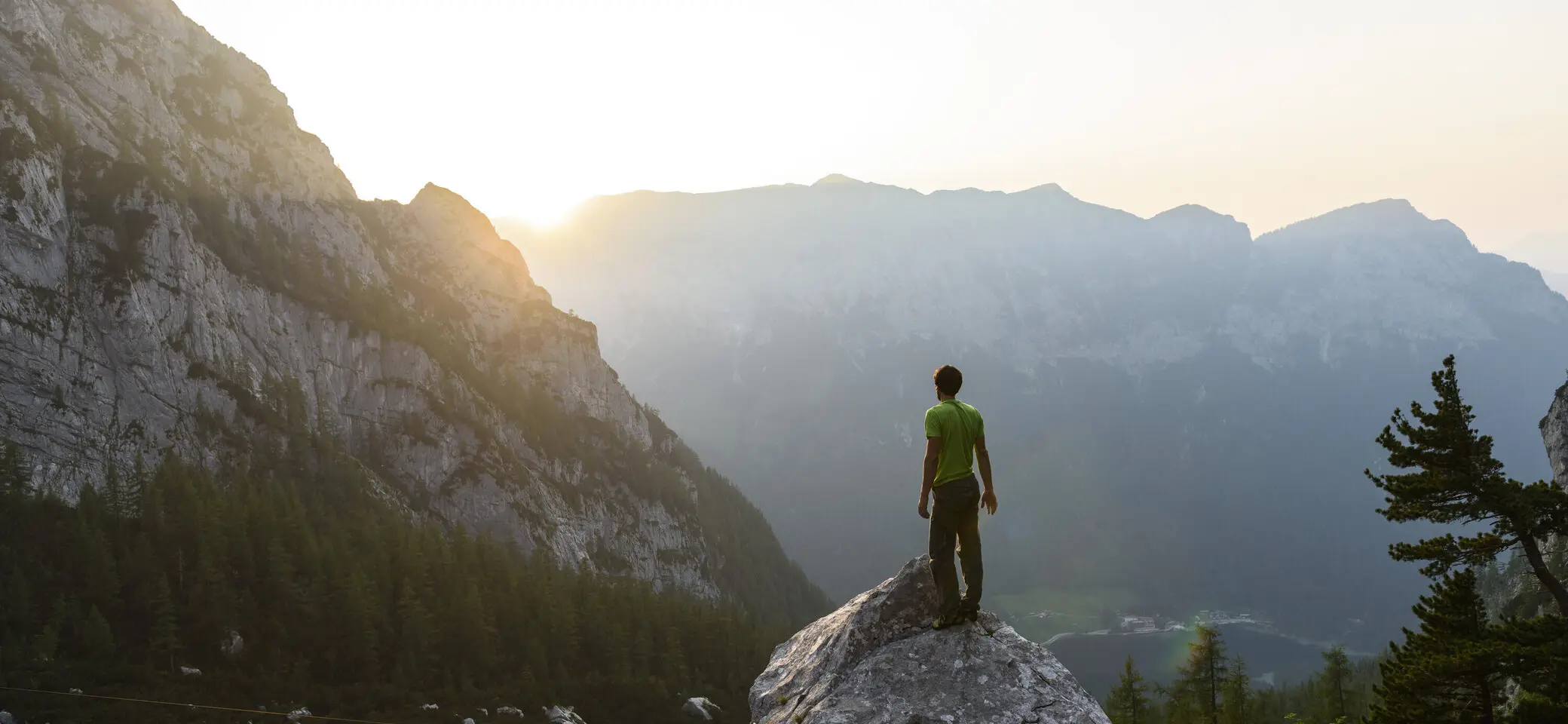 Ein Mann genießt auf einem Felsen den Sonnenuntergang | © DAV/Wolfgang Ehn